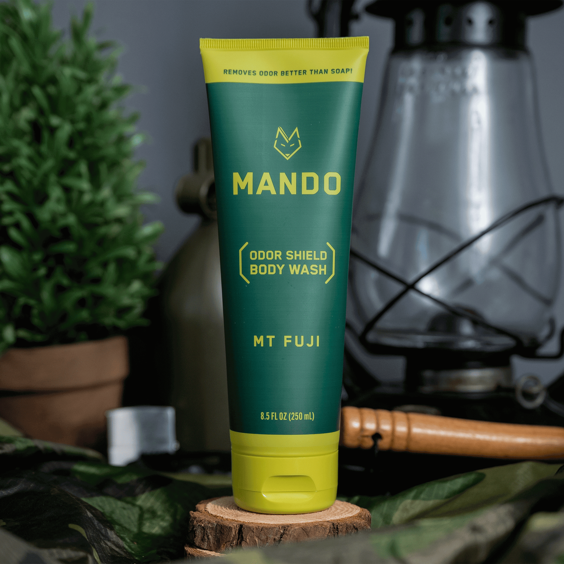 yellow green tube of Mando body wash in Mt Fuji scent placed on wood with a lantern in the background