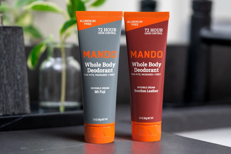 line up of 4 Mando cream deodorants in bourbon leather and mt fuji placed on a counter top
