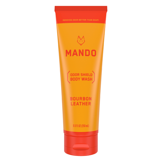 Yellow orange tube of Mando body wash in bourbon leather scent on white background 