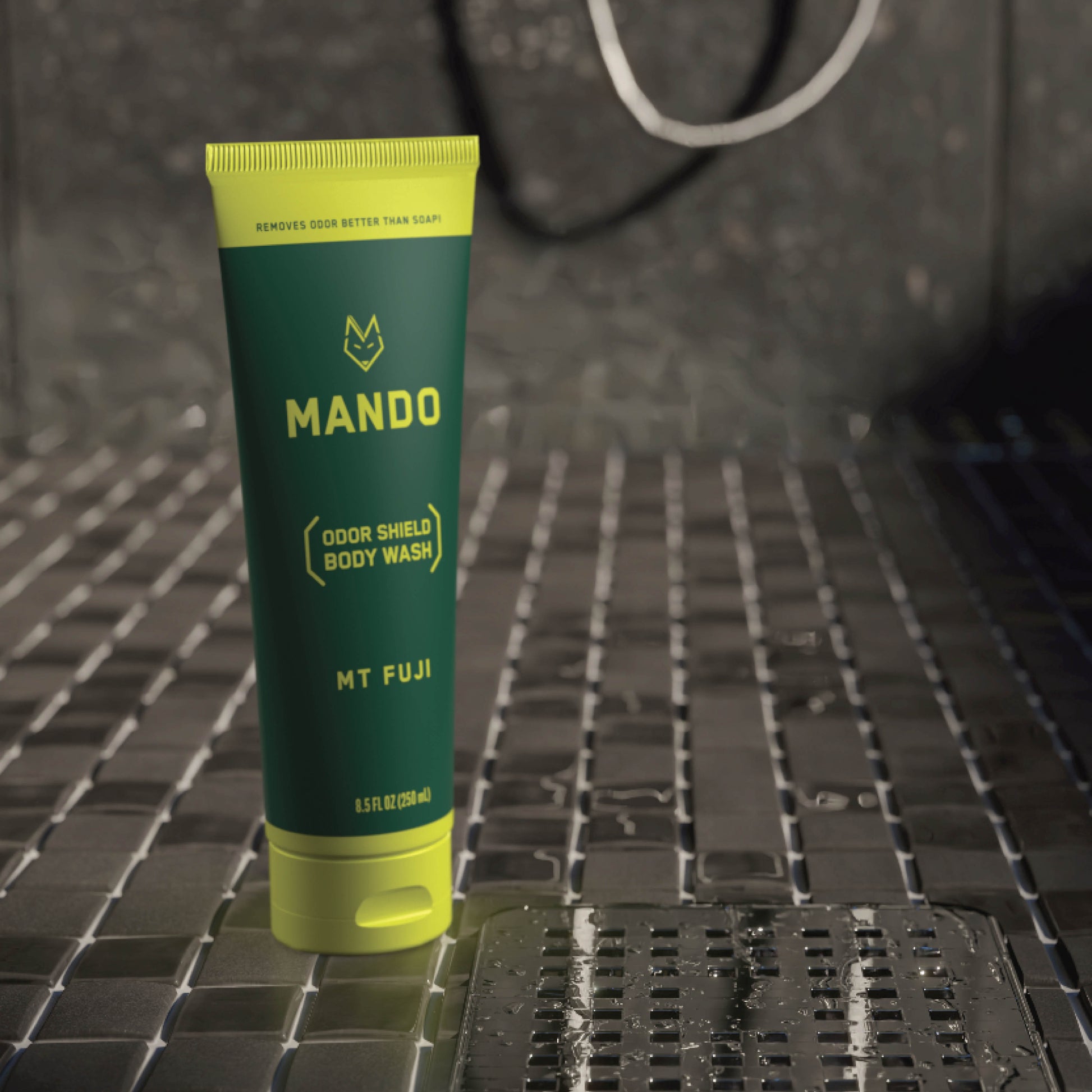 yellow green tube of Mando body wash in mt fuji scent standing on shower floor 