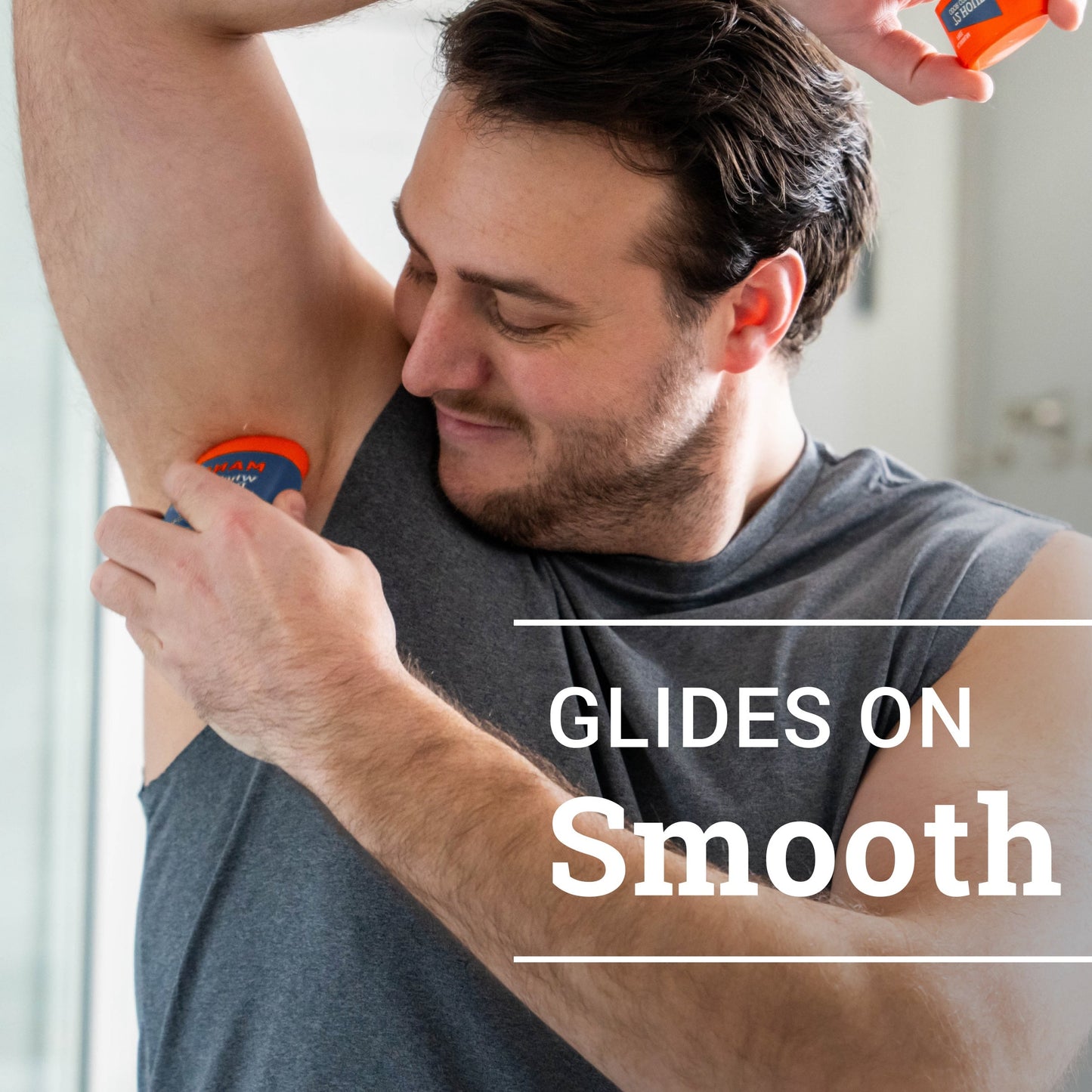 man smiling while applying pro sport solid stick deodorant to armpit with text: glides on smooth